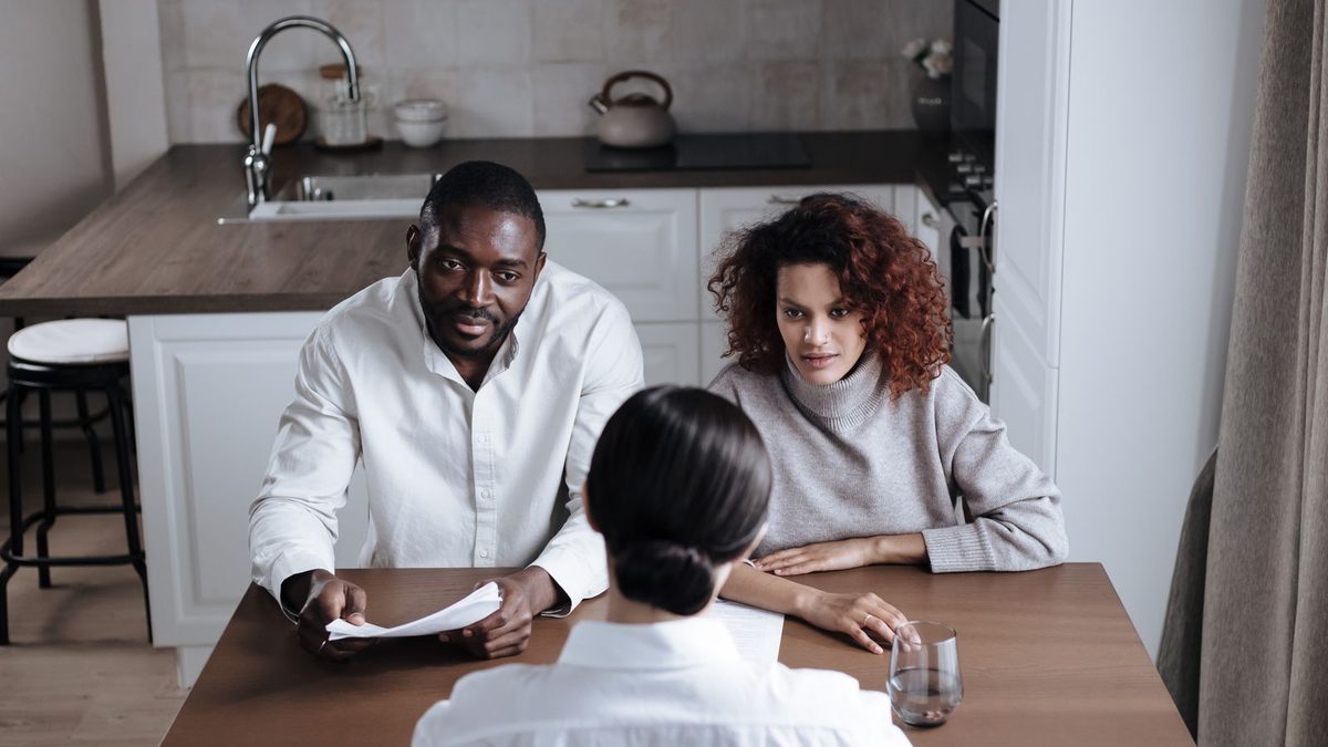 Couple écoutant une conseillère expliquer un contrat