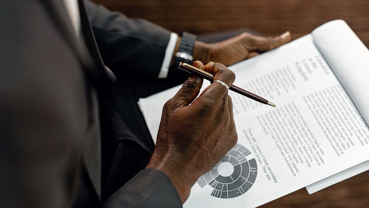 Mains annotant au stylo un document chiffré