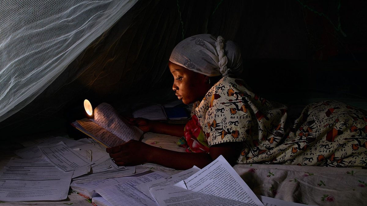 Enfant installé sur un lit sous une moustiquaire