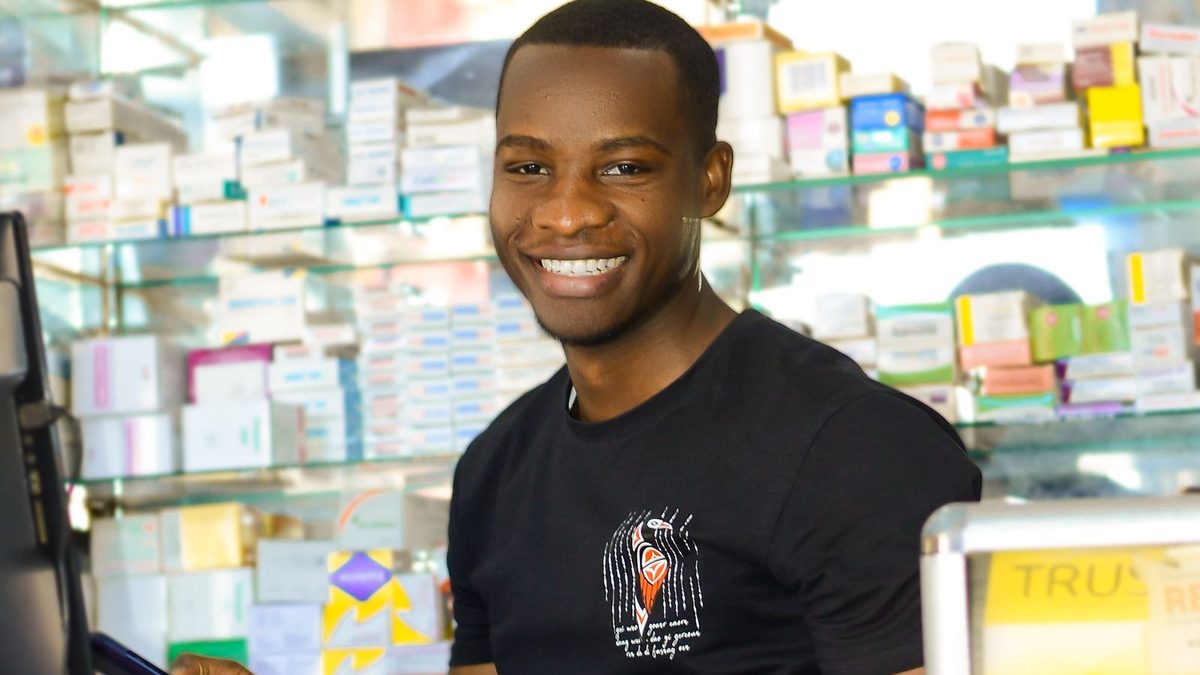Pharmacien au comptoir enregistrant une transaction