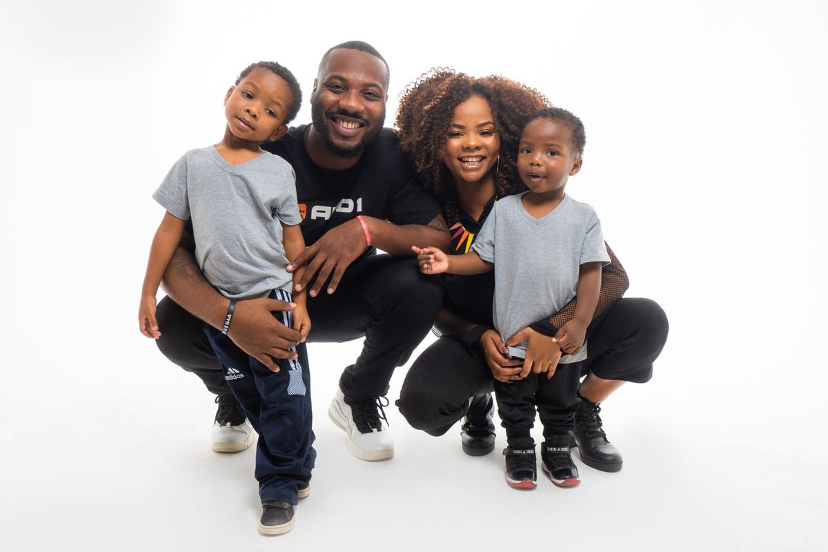 Famille africaine souriante, deux parents et deux jeunes enfants